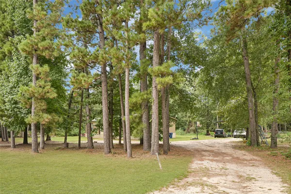 a big yard with trees in front of it
