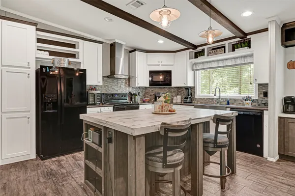 a kitchen with kitchen island granite countertop a sink appliances cabinets and furniture