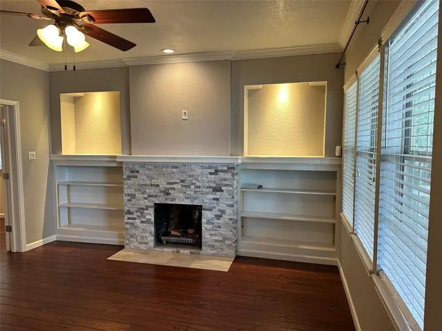 a living room with wooden floor and a fireplace