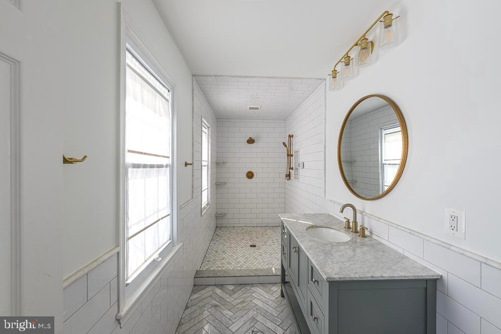 2510 Little River Road Haymarket, VA 20169 - Photo 21 of 39 a bathroom with a granite countertop sink a mirror and a shower