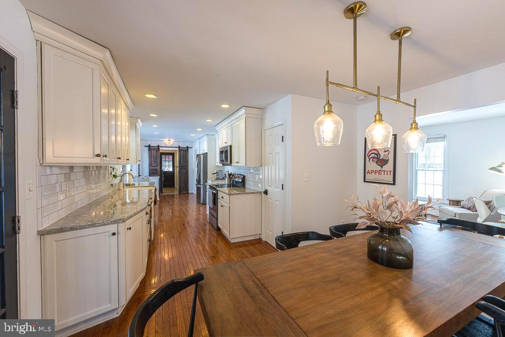 2510 Little River Road Haymarket, VA 20169 - Photo 9 of 39 a kitchen with kitchen island a stove a sink a center island and living room view