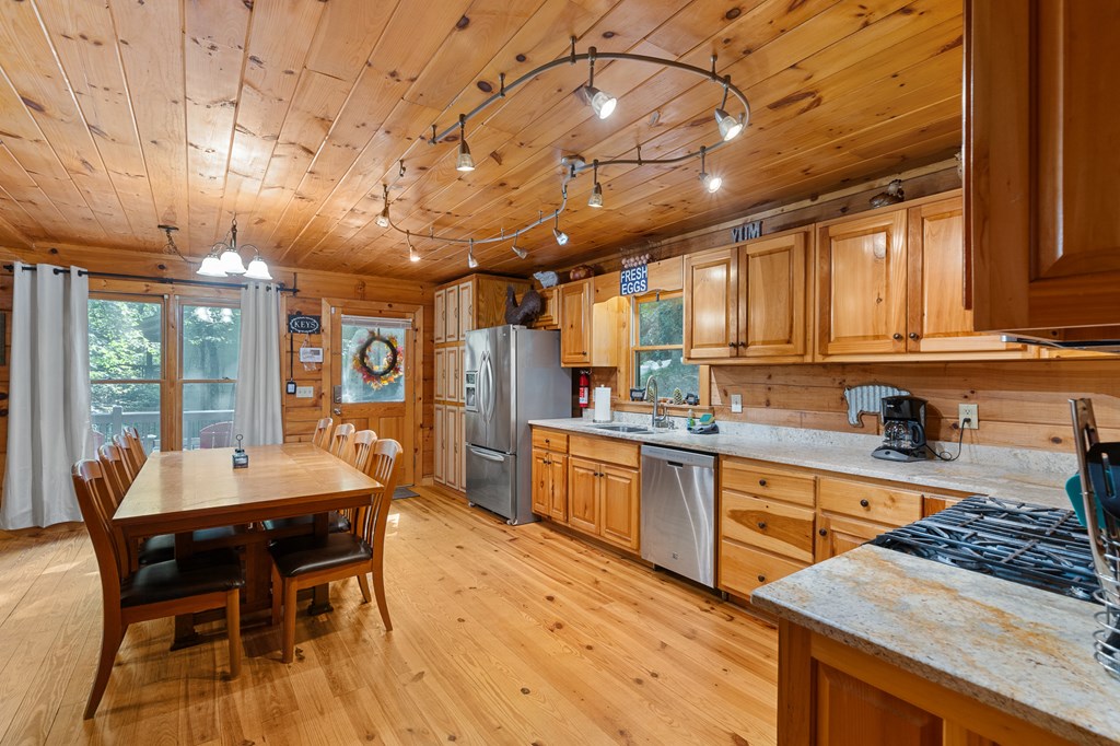 93 Amy Lane Ellijay, GA 30540 - Photo 14 of 61 a kitchen with stainless steel appliances granite countertop a stove a sink dishwasher a dining table and chairs with wooden floor
