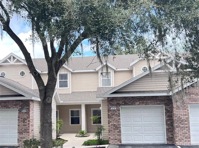 a view of a white house with large tree