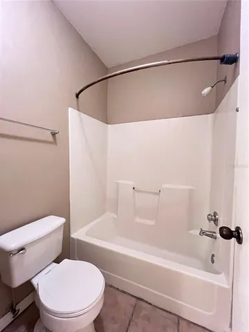 a white toilet sitting next to a bath tub