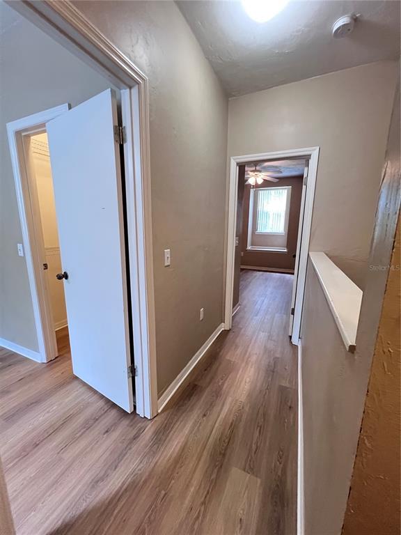 4700 Southwest Archer Road, Unit M90 Gainesville, FL 32608 - Photo 21 of 35 an empty room with wooden floor and stairs