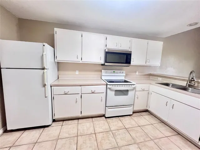 a kitchen with cabinets stainless steel appliances and a sink