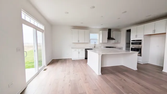 a kitchen with a refrigerator and a stove top oven