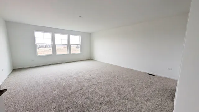 an empty room with a windows and chandelier