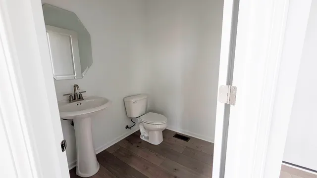 a bathroom with a toilet a sink and a mirror