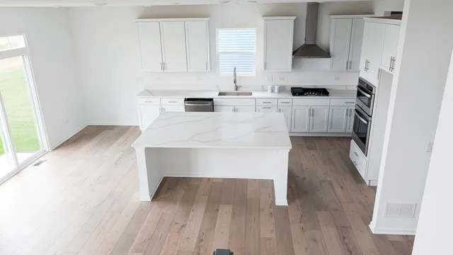 a kitchen with stainless steel appliances a stove a sink and white cabinets