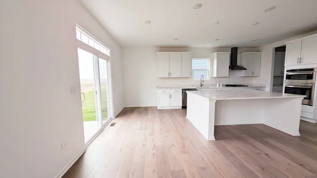 a view of kitchen with wooden floor and electronic appliances