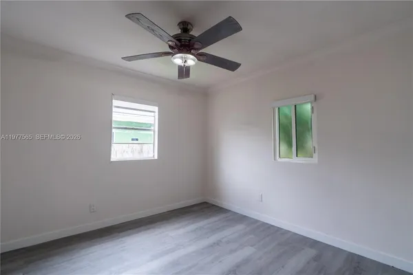 an empty room with a window and a fan