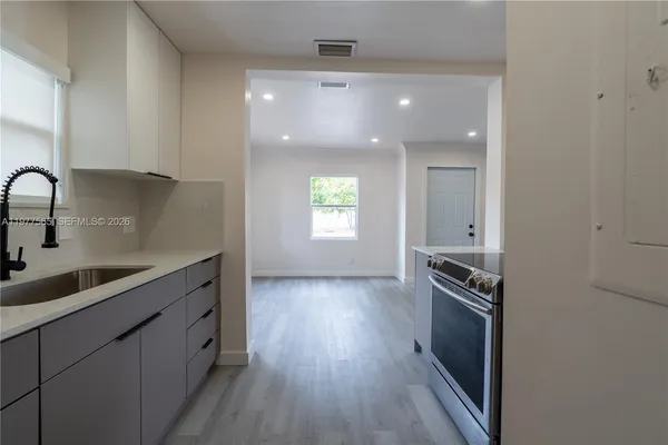 a kitchen with granite countertop a stove and a sink