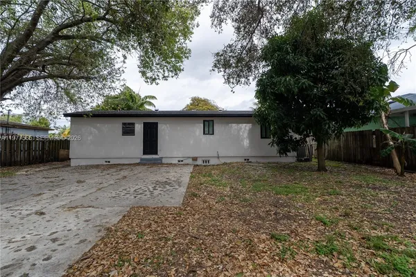 a view of a house with a yard and large tree