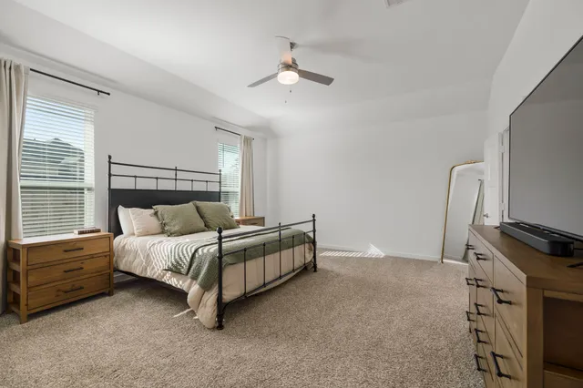 a bedroom with a bed dresser and a window