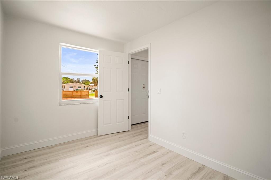 2316 Bayside Street Naples, FL 34112 - Photo 13 of 24 a view of an empty room with wooden floor and a window