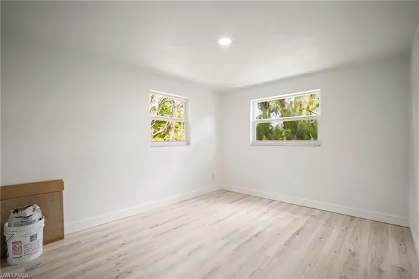 an empty room with a wooden floor and window