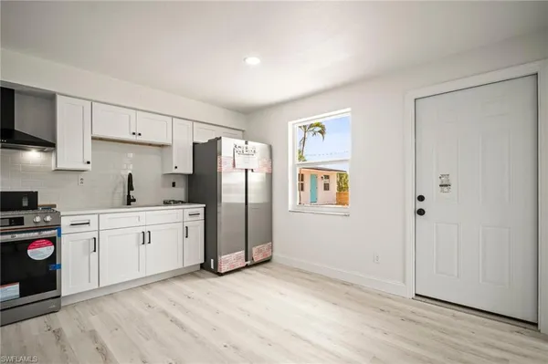 a kitchen with a refrigerator a stove and wooden cabinets