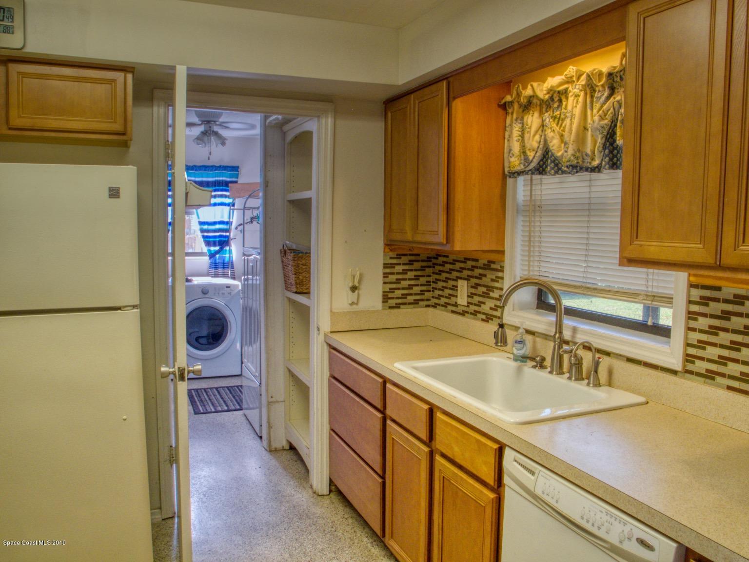 2268 Woodbury Road Melbourne, FL 32935 - Photo 9 of 20 KITCHEN LEADS INTO LAUNDRY ROOM