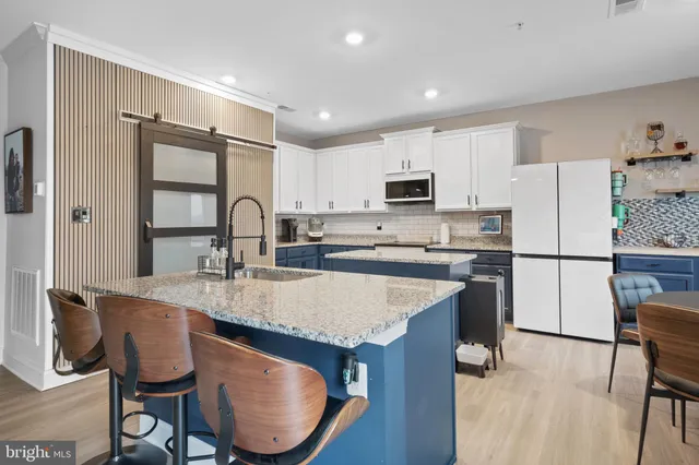 a kitchen with kitchen island a sink stove and refrigerator