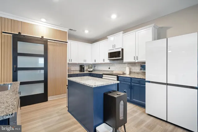 a kitchen with kitchen island granite countertop cabinets and refrigerator