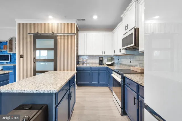 a kitchen with stainless steel appliances granite countertop a kitchen island a stove a sink and a refrigerator