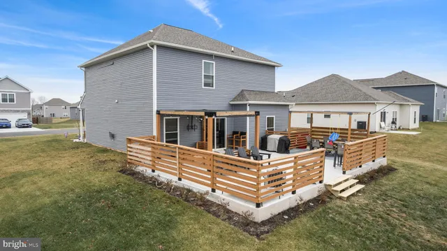a white house with a small yard and large trees
