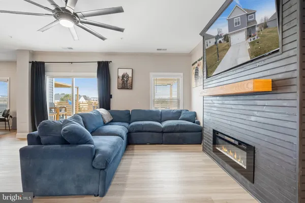 a living room with furniture a ceiling fan and a window
