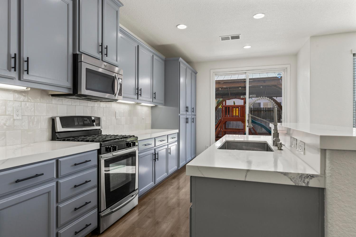 2836 Tabriz Drive Modesto, CA 95355 - Photo 13 of 35 a kitchen with stainless steel appliances a sink stove and cabinets