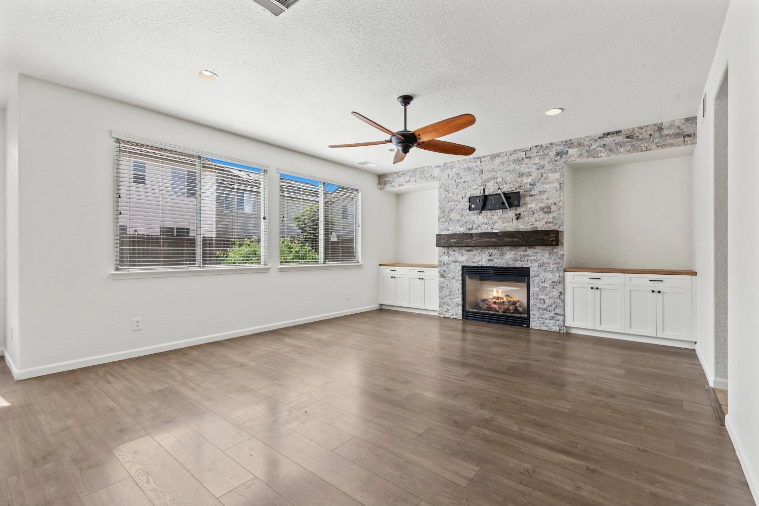 2836 Tabriz Drive Modesto, CA 95355 - Photo 15 of 35 a view of a livingroom with a fireplace a ceiling fan and windows
