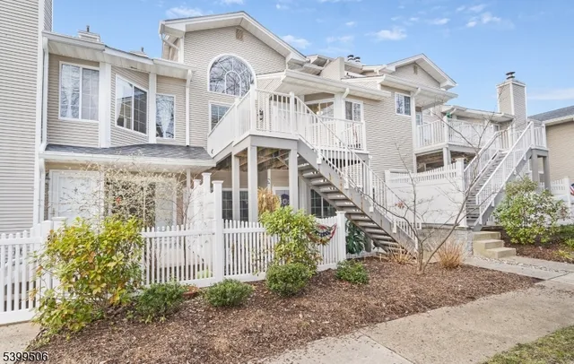 a view of a white building among the front of a yard