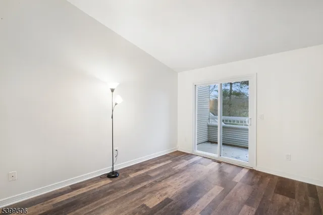 an empty room with wooden floor and a window