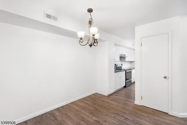 a view of a room with wooden floor and white walls