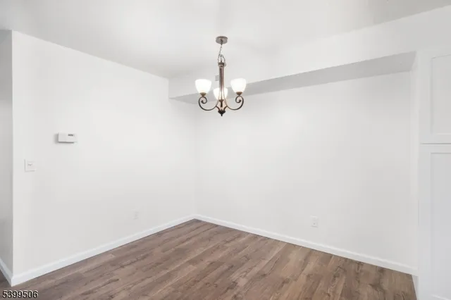 a view of a room with wooden floor and chandelier