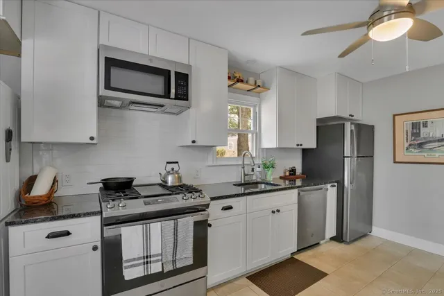 a kitchen with stainless steel appliances granite countertop a sink a stove a microwave and cabinets