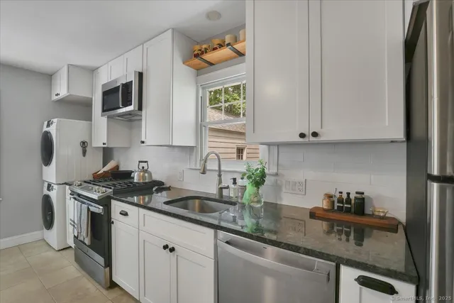 a kitchen with stainless steel appliances granite countertop a sink a stove and a microwave