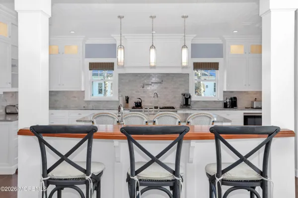 a large kitchen with kitchen island a large counter space a sink appliances and a living room view