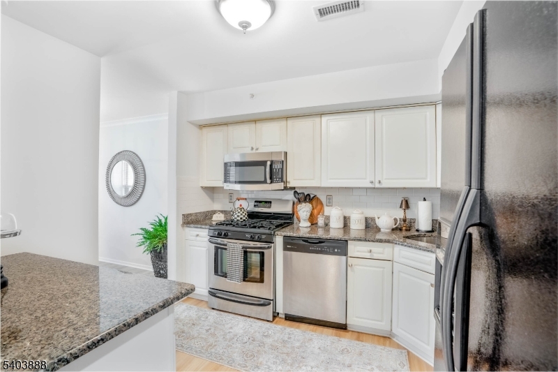 8 Springholm Drive Berkeley Heights, NJ 07922 - Photo 13 of 19 a kitchen with stainless steel appliances granite countertop a sink a stove a microwave a refrigerator and cabinets