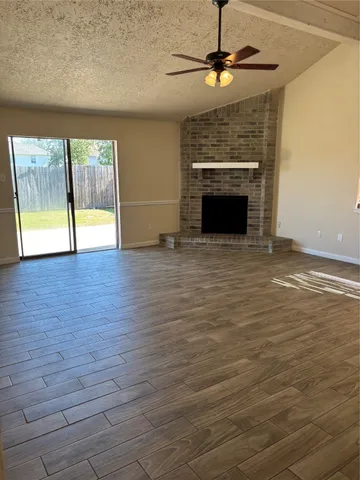 a view of an empty room with a fireplace and a window