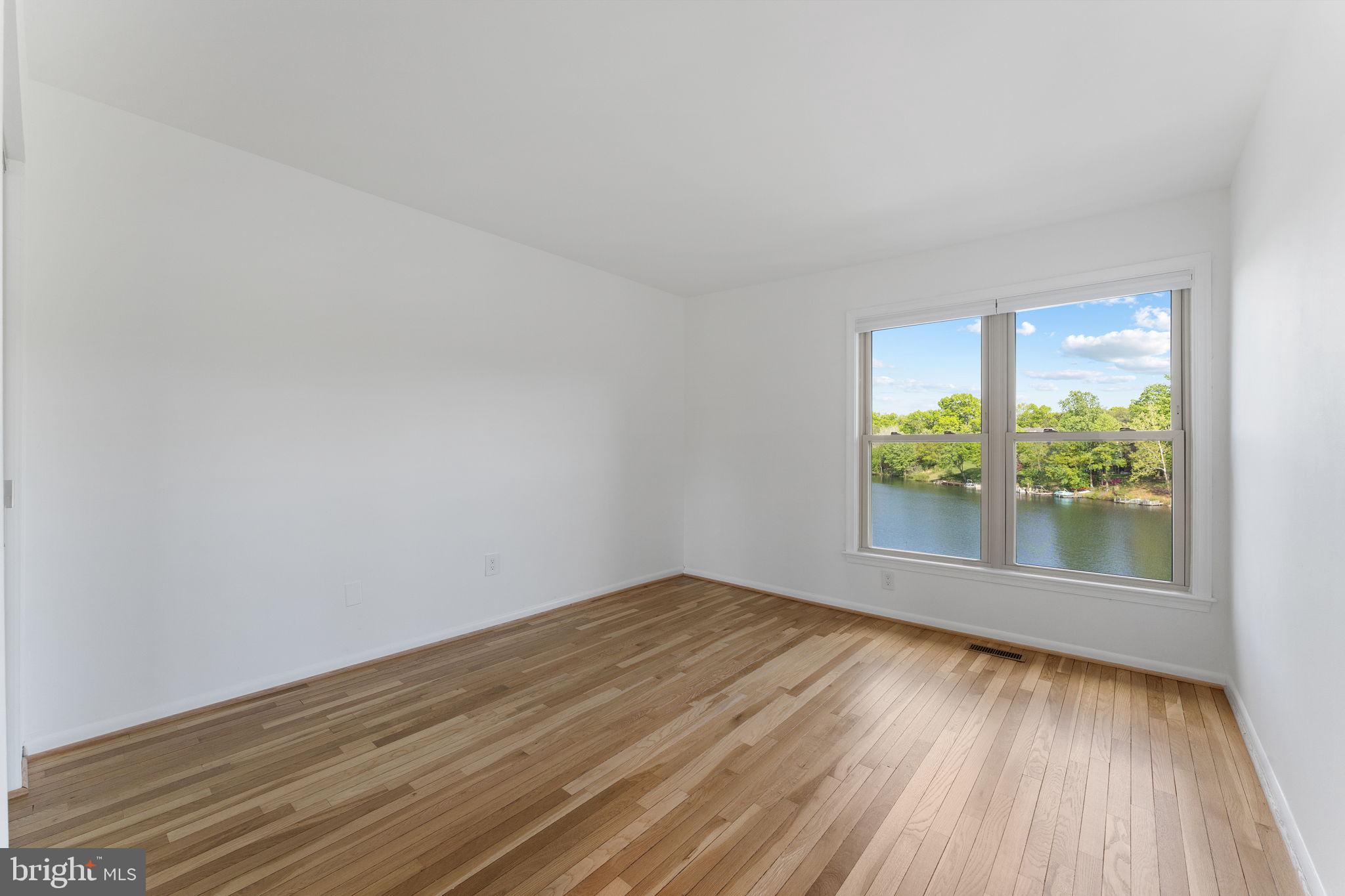 11163 Lake Chapel Lane Reston, VA 20191 - Photo 42 of 129 an empty room with wooden floor and windows