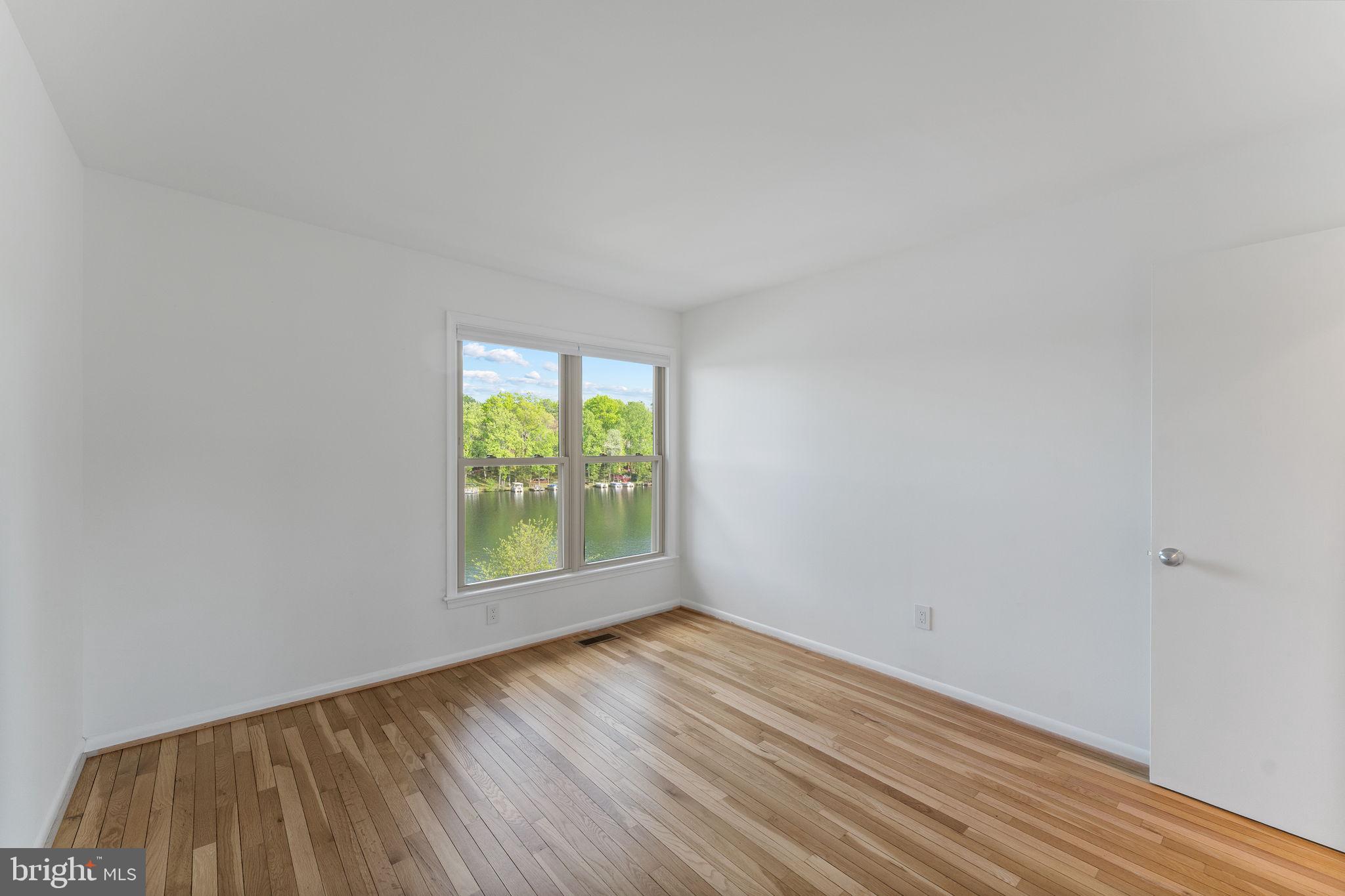 11163 Lake Chapel Lane Reston, VA 20191 - Photo 49 of 129 a view of an empty room with wooden floor and a window