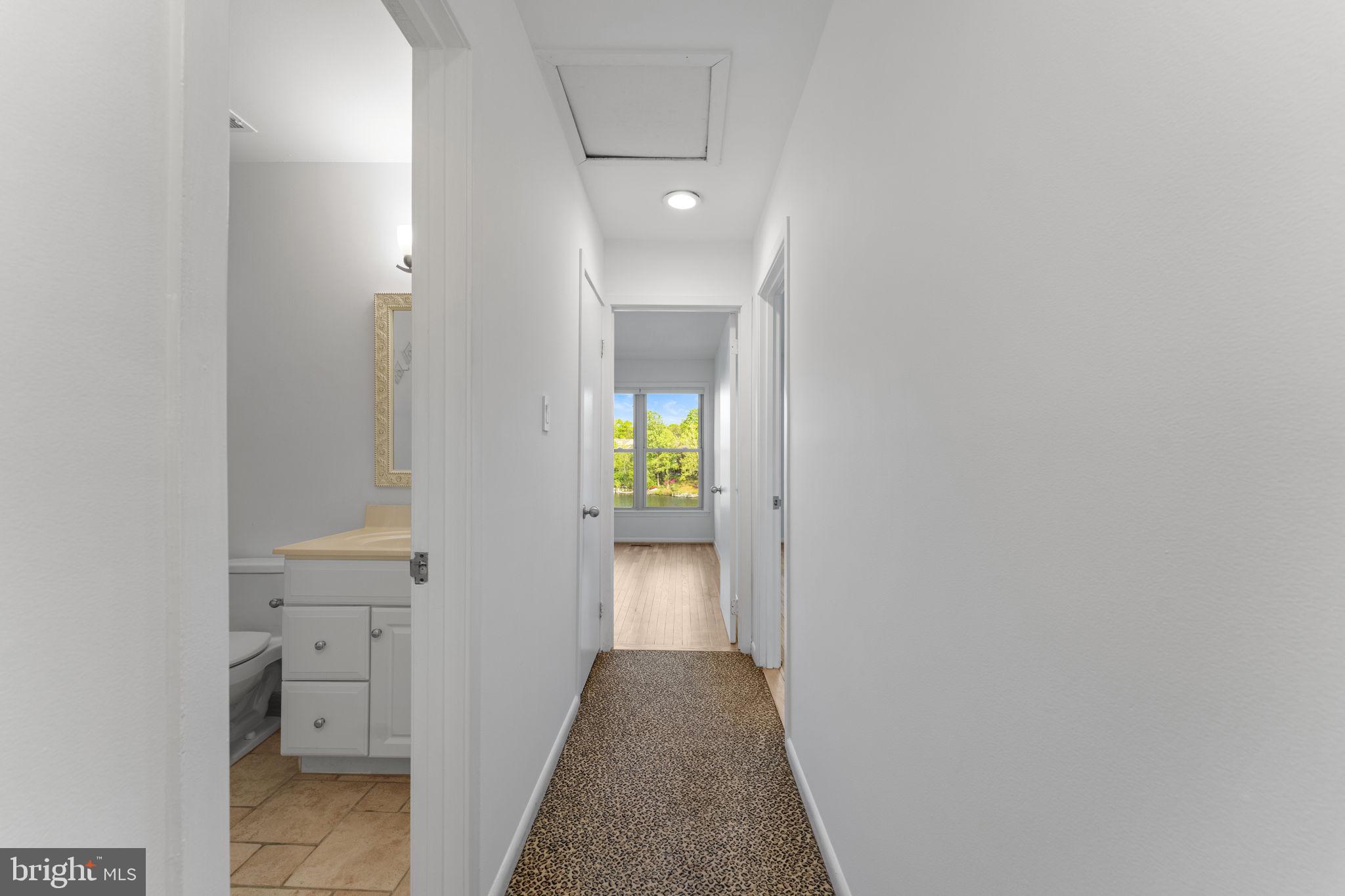 11163 Lake Chapel Lane Reston, VA 20191 - Photo 51 of 129 a view of a hallway with wooden floor and a bathroom