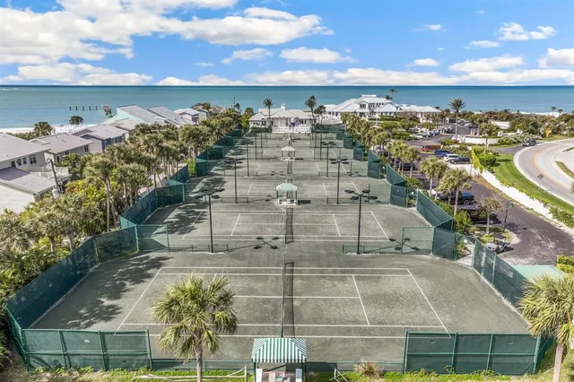 a room with lots of wooden furniture wooden floor and large windows
