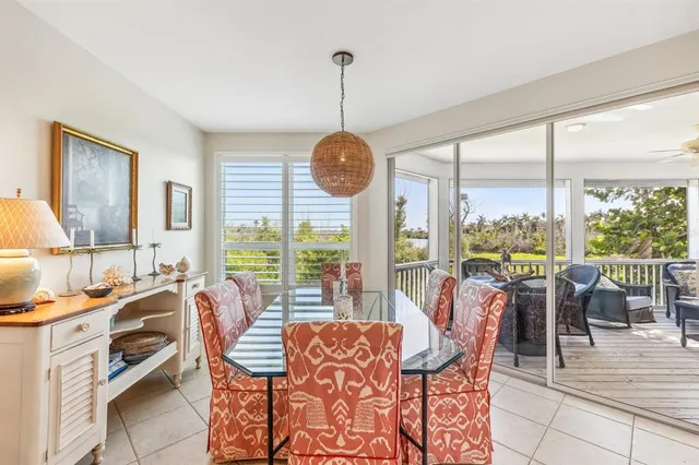 a dining room with furniture a chandelier and glass windows
