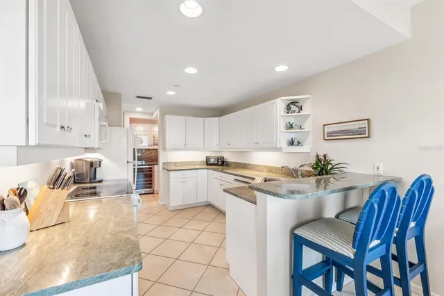 a kitchen with a sink a stove a refrigerator cabinets and dining table