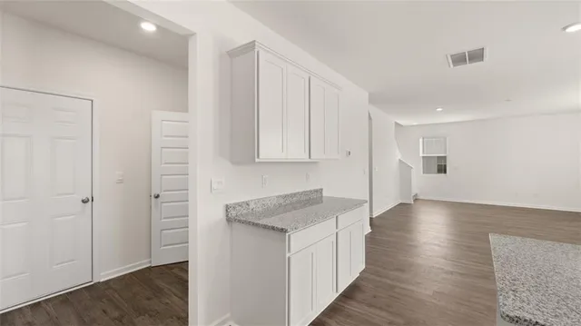 a view of a kitchen with wooden floor and staircase