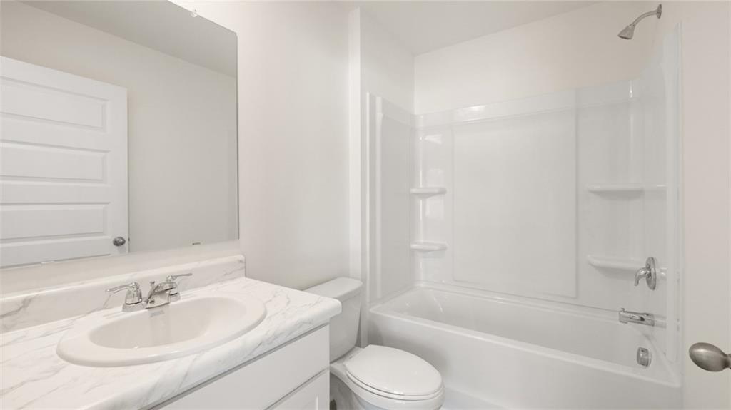 73 Weymouth Drive Locust Grove, GA 30248 - Photo 44 of 47 a bathroom with a bathtub shower sink and a toilet