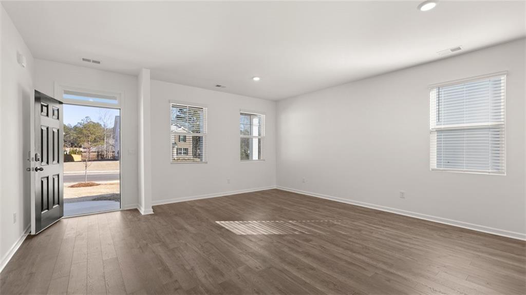 73 Weymouth Drive Locust Grove, GA 30248 - Photo 7 of 47 an empty room with wooden floor and windows