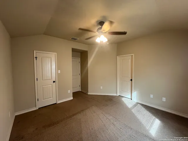 a view of an empty room and a ceiling fan