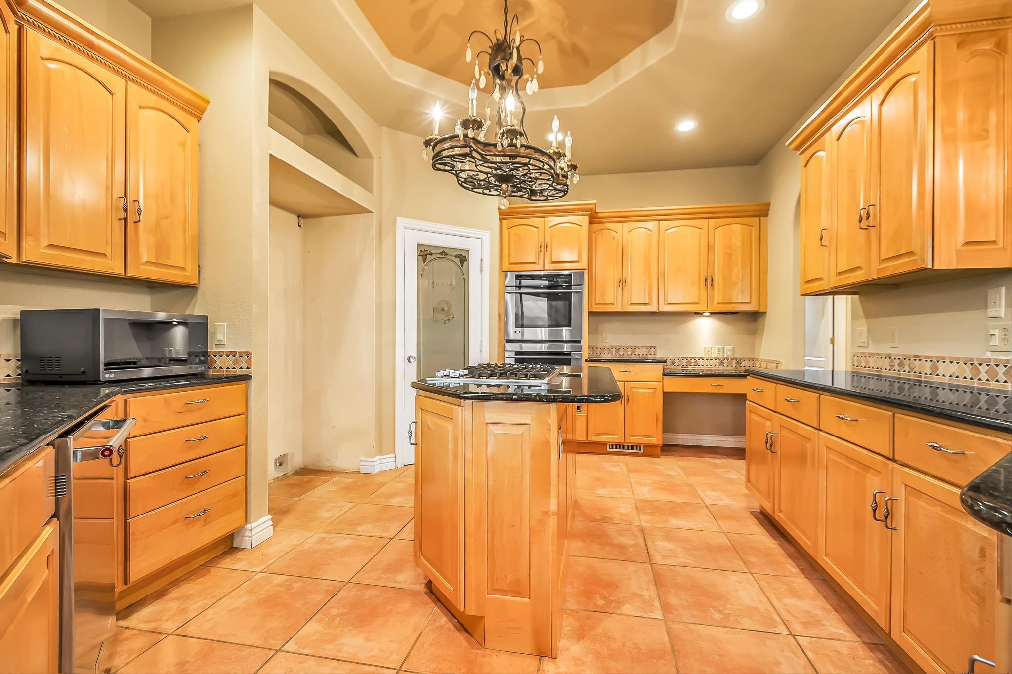 2224 H Road Grand Junction, CO 81505 - Photo 20 of 42 a large kitchen with kitchen island granite countertop a large counter top space appliances and cabinets
